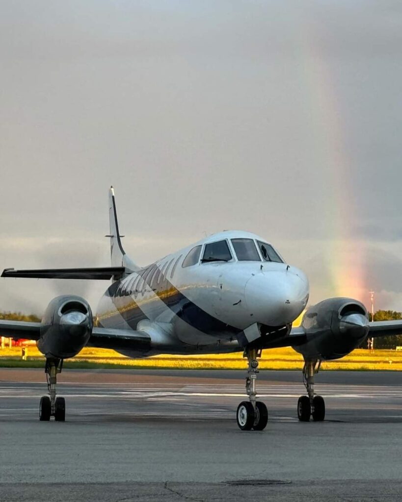 SkyCare Metroliner aircraft on the apron with a rainbow in the background