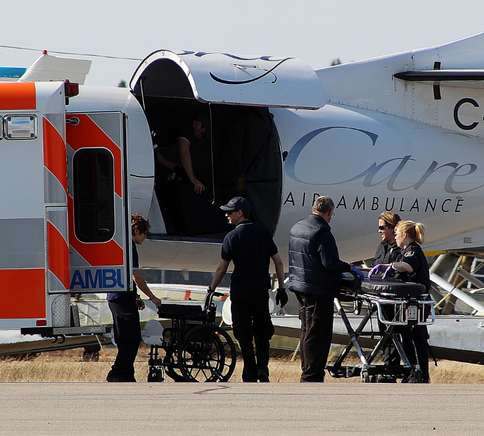 SkyCare medical crew preparing a patient for loading onto a Metro medevac aircraft